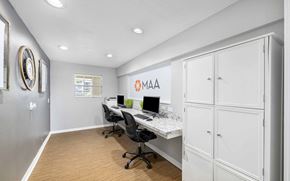 Jacksonville apartment for rent - A white office space with a desk, chairs, and cabinets.