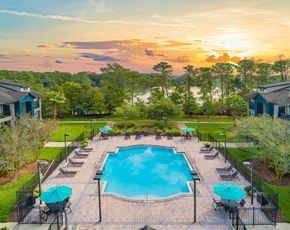 Jacksonville apartment for rent - an aerial view of a swimming pool with umbrellas at sunset
