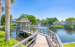 Jacksonville apartment for rent - a wooden bridge leading to a lake with a gazebo and water fountain