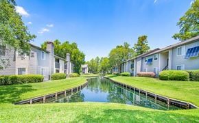 Jacksonville apartment for rent - a pond in the middle of a grassy area between houses