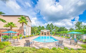 Jacksonville apartment for rent - a swimming pool with chairs and umbrellas at the resort