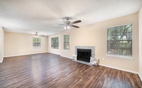 Jacksonville apartment for rent - an empty living room with a fireplace and a ceiling fan