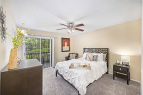 Jacksonville apartment for rent - a bedroom with a bed and a ceiling fan