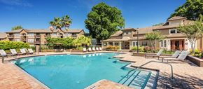 Jacksonville apartment for rent - a swimming pool with chairs and a building in the background