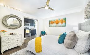 Jacksonville apartment for rent - a bedroom with a white bed and a ceiling fan