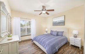 Tallahassee apartment for rent - A bedroom with a bed, nightstand, and window.