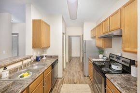Tallahassee apartment for rent - A kitchen with wooden cabinets and a black stove top.