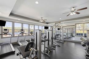 Savannah apartment for rent - A spacious gym with treadmills, weight machines, and a ceiling fan.