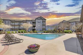 Pooler apartment for rent - A sunset view of a pool area with lounge chairs and a building in the background.