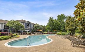Charlotte apartment for rent - A swimming pool surrounded by a brick patio and lounge chairs.