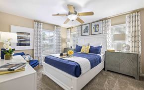 Charlotte apartment for rent - A bedroom with a bed, nightstand, and a ceiling fan.