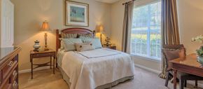 Charlotte apartment for rent - a bedroom with a bed and a dresser and a window