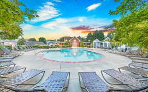 Charlotte apartment for rent - a swimming pool with chaise lounge chairs and a building in the background