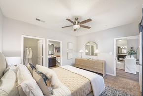 Charlotte apartment for rent - A bedroom with a large bed and a ceiling fan.