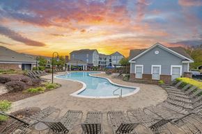 Charlotte apartment for rent - A swimming pool surrounded by lounge chairs in a residential area.