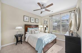 Huntersville apartment for rent - A bedroom with a bed, nightstand, and a ceiling fan.
