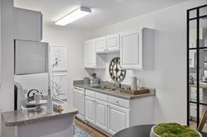 Charlotte apartment for rent - A modern kitchen with white cabinets and a granite countertop.