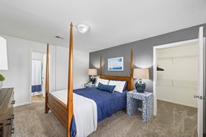 Charlotte apartment for rent - A bedroom with a four poster bed and a blue bedspread.