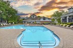 Midlothian apartment for rent - A large swimming pool in front of a house with a sunset in the background.