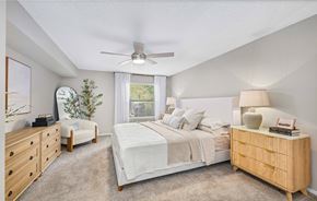 Hampton apartment for rent - A bedroom with a large bed, a dresser, and a ceiling fan.