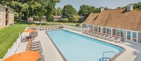 Fredericksburg apartment for rent - a swimming pool with orange umbrellas and chairs around it