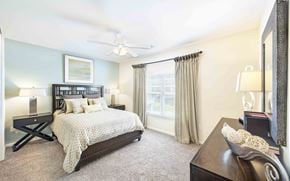 Fredericksburg apartment for rent - A bedroom with a bed, nightstand, and a ceiling fan.