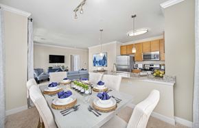 Fredericksburg apartment for rent - a dining room table with white chairs and a kitchen in the background