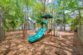 Matthews apartment for rent - A playground with a green slide and a brown wooden structure.