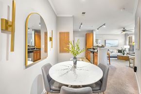 Matthews apartment for rent - A modern dining room with a round marble table and grey chairs.