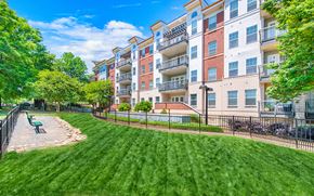 Charlotte apartment for rent - a park with a bench in front of an apartment building
