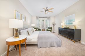 Charlotte apartment for rent - A bedroom with a bed, nightstand, and a ceiling fan.
