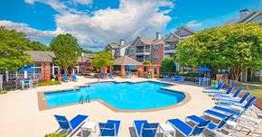 Durham apartment for rent - A large swimming pool surrounded by blue lounge chairs.