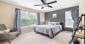 Durham apartment for rent - A bedroom with a bed, chair, and window.