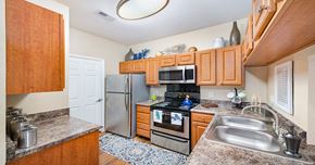 Durham apartment for rent - A kitchen with wooden cabinets and a refrigerator.