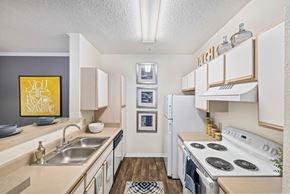 Raleigh apartment for rent - A kitchen with a stove top oven and a fridge.