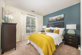 Durham apartment for rent - A bedroom with a bed, nightstand, and a painting on the wall.