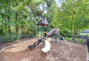 Durham apartment for rent - A playground with a slide, a wooden structure, and a climbing frame.