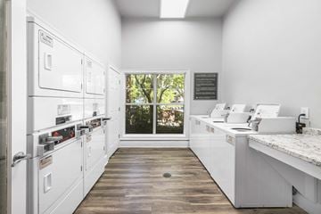 Durham apartment for rent - A kitchen with white appliances and a window showing trees outside.