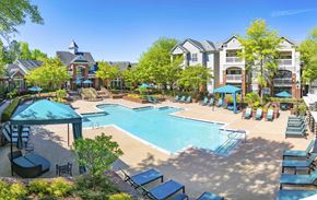 Durham apartment for rent - A large swimming pool surrounded by lounge chairs and umbrellas.