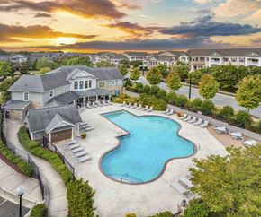 Raleigh apartment for rent - an aerial view of a swimming pool at sunset with houses