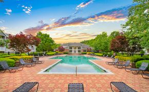 Cary apartment for rent - a swimming pool with lounge chairs and a house in the background