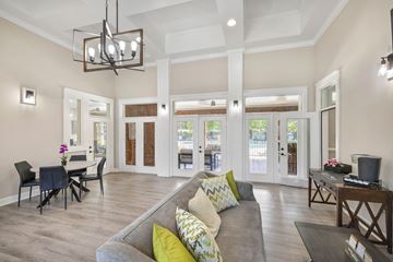 Raleigh apartment for rent - A living room with a grey couch and a chandelier.