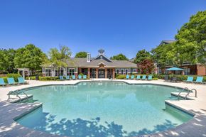 Raleigh apartment for rent - A large swimming pool with a building in the background.
