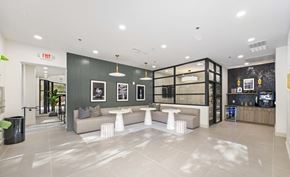 Raleigh apartment for rent - A modern lobby with a grey couch and a white coffee table.