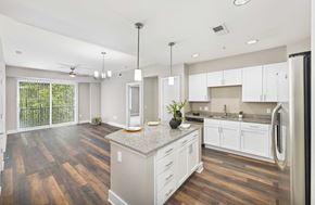 Raleigh apartment for rent - A kitchen with white cabinets and a wooden floor.