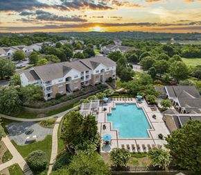 Hendersonville apartment for rent - an aerial view of the resort style pool at sunset with apartments in the background