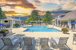 Hendersonville apartment for rent - a swimming pool with chairs around it and a house with a pool