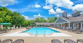 Murfreesboro apartment for rent - A large swimming pool surrounded by lounge chairs and trees.