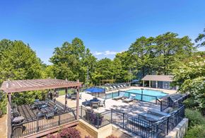 Chattanooga apartment for rent - A pool area with a table and chairs under a pergola.