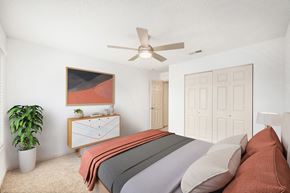 Huntsville apartment for rent - A bedroom with a bed, dresser, and ceiling fan.